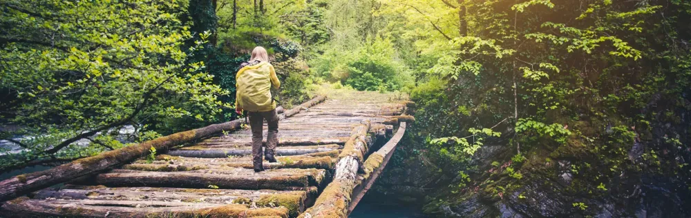 woman hiking on bridge